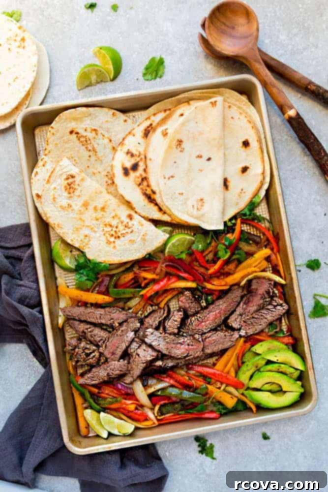Sheet Pan Magic: Effortless Dinner Ideas 6 Sheet Pan Steak Fajitas with bell peppers and onions, ready to be served