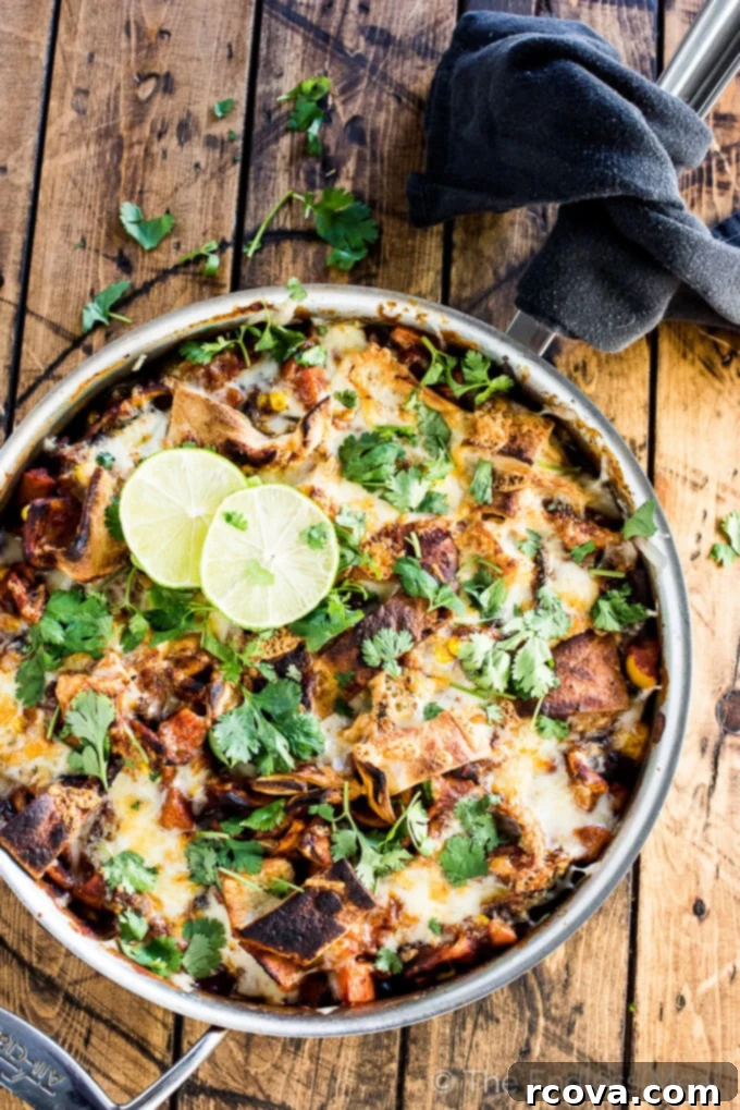 Quick and Wholesome One Pan Meals 26 Summer vegetarian skillet enchiladas in a skillet on a wooden table.