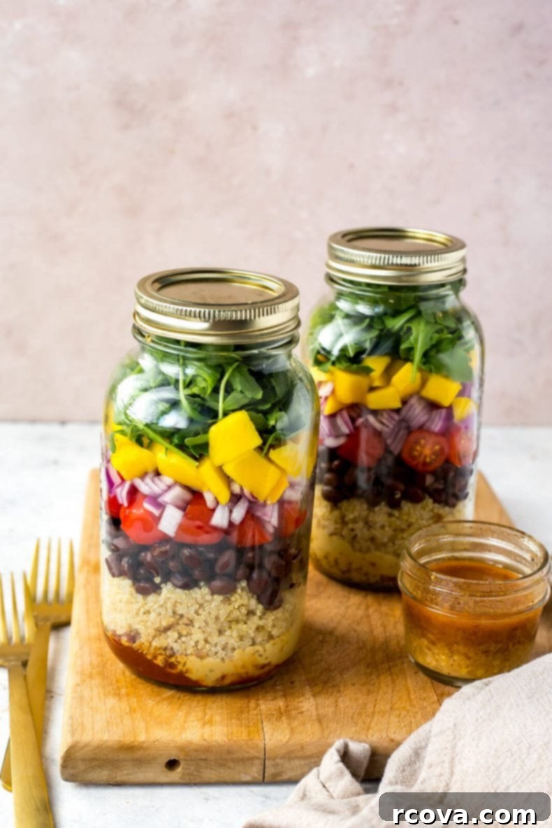 Ultimate Veggie Mason Jar Salad Two Ways 7 A hand holding a vegetarian mason jar salad with colorful layers, ready to be enjoyed.