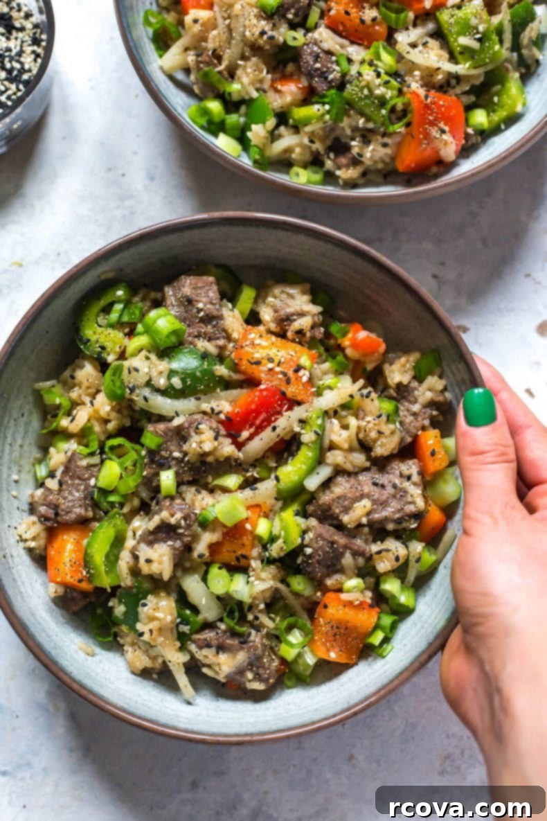Quick and Tender Instant Pot Pepper Steak 2 Delicious Instant Pot Pepper Steak with tender beef, fluffy rice, and colorful bell peppers, garnished with green onions and sesame seeds