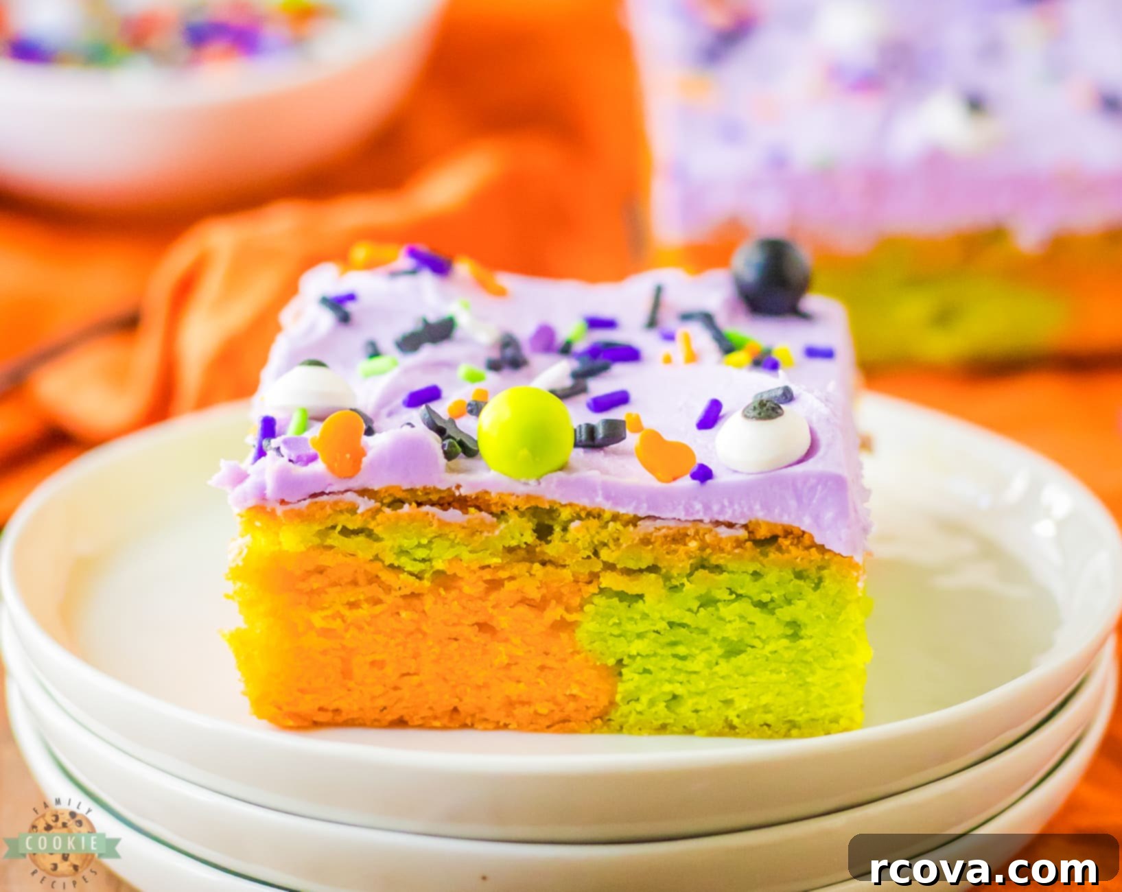 Festive Halloween Sugar Cookie Bars 2 marbled orange and green Halloween sugar cookie bars with purple frosting on a plate