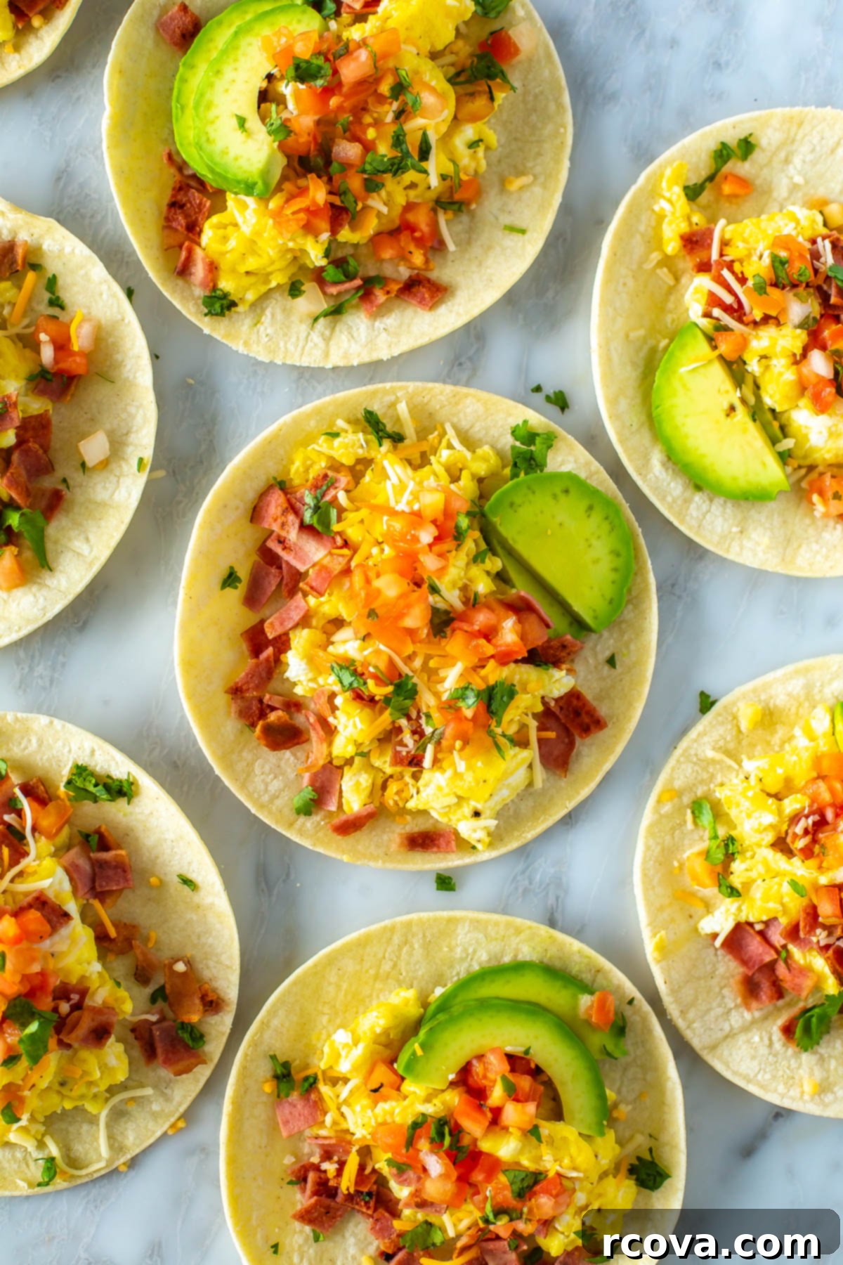 Fuel Your Mornings: Healthy Breakfast Prep 27 An overhead shot of breakfast tacos topped with eggs, bacon, pice de gallo, avocado and cheese.