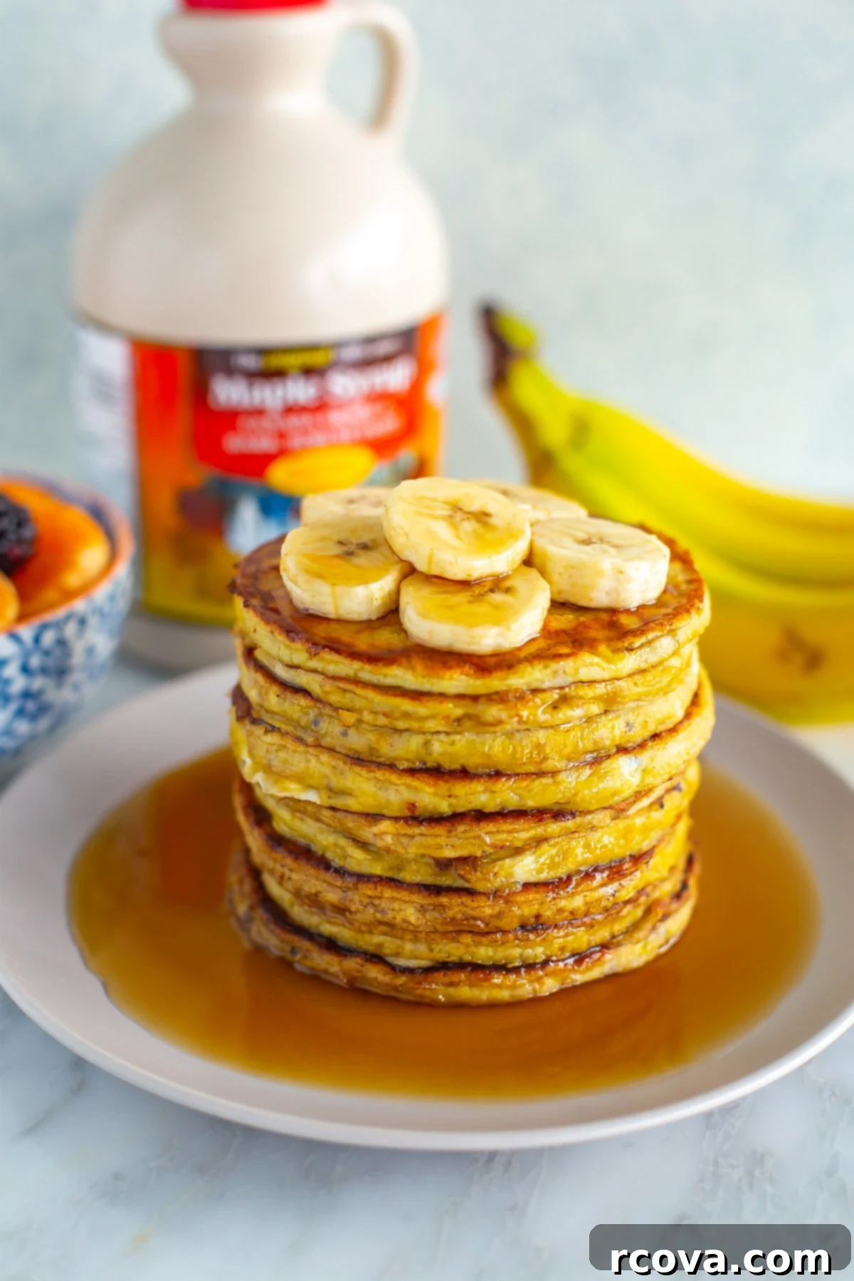 Fuel Your Mornings: Healthy Breakfast Prep 10 A stack of banana egg pancakes with extra banana slices and maple syrup on top.