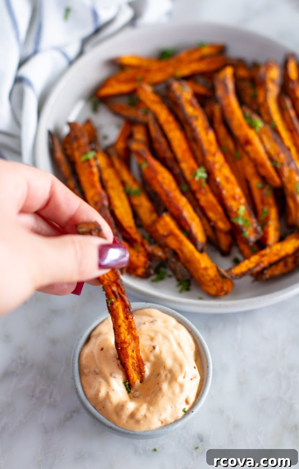 Guilt-Free Air Fryer Sweet Potato Gold 7 Sweet potato fries being dipped in creamy chipotle sauce