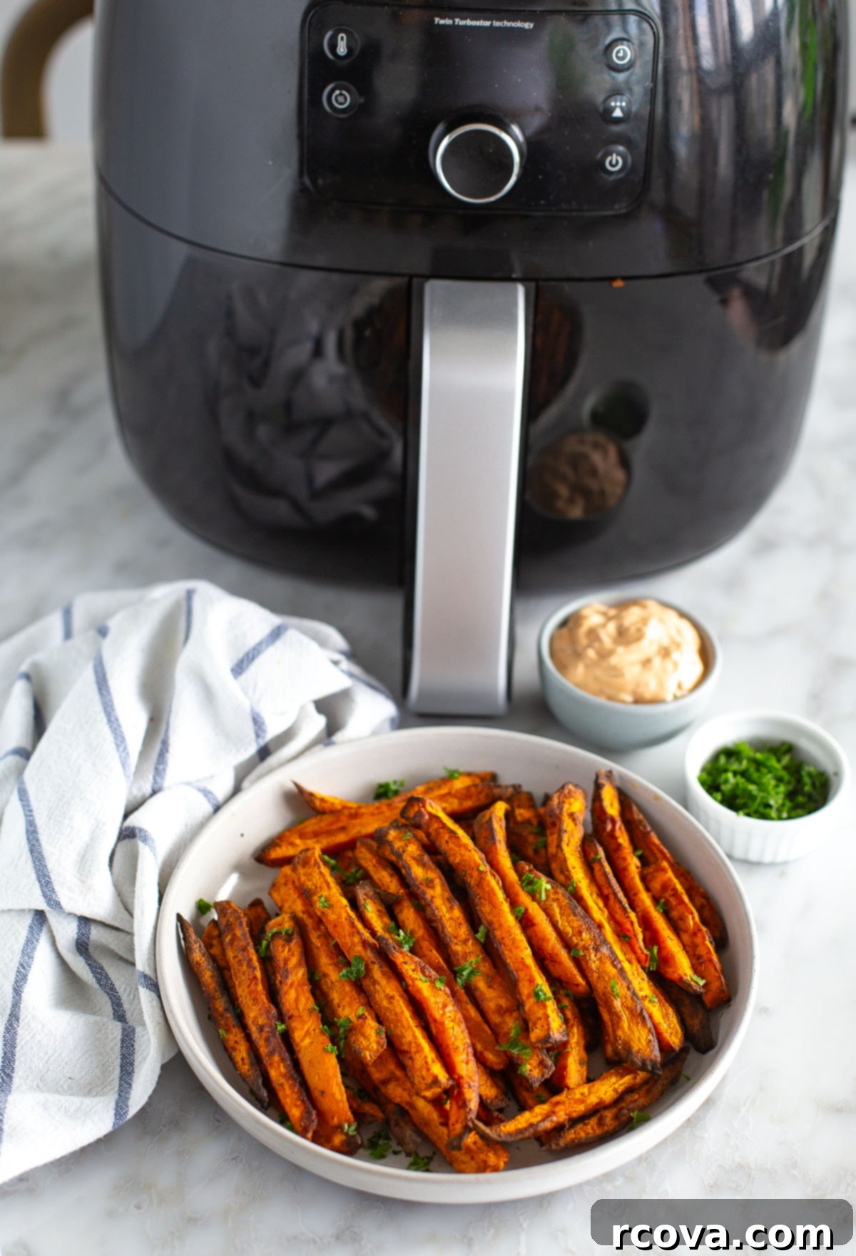 Guilt-Free Air Fryer Sweet Potato Gold 8 Sweet potato fries in a bowl next to an air fryer, highlighting the convenience of the appliance