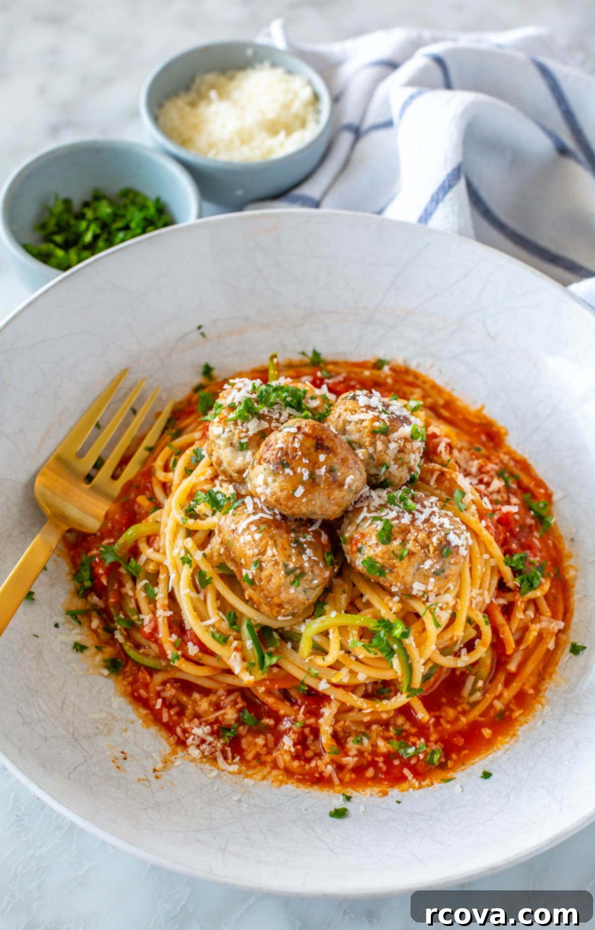 Effortless Oven Baked Turkey Meatballs 7 Baked turkey meatballs served on top of a bed of pasta and zucchini noodles.