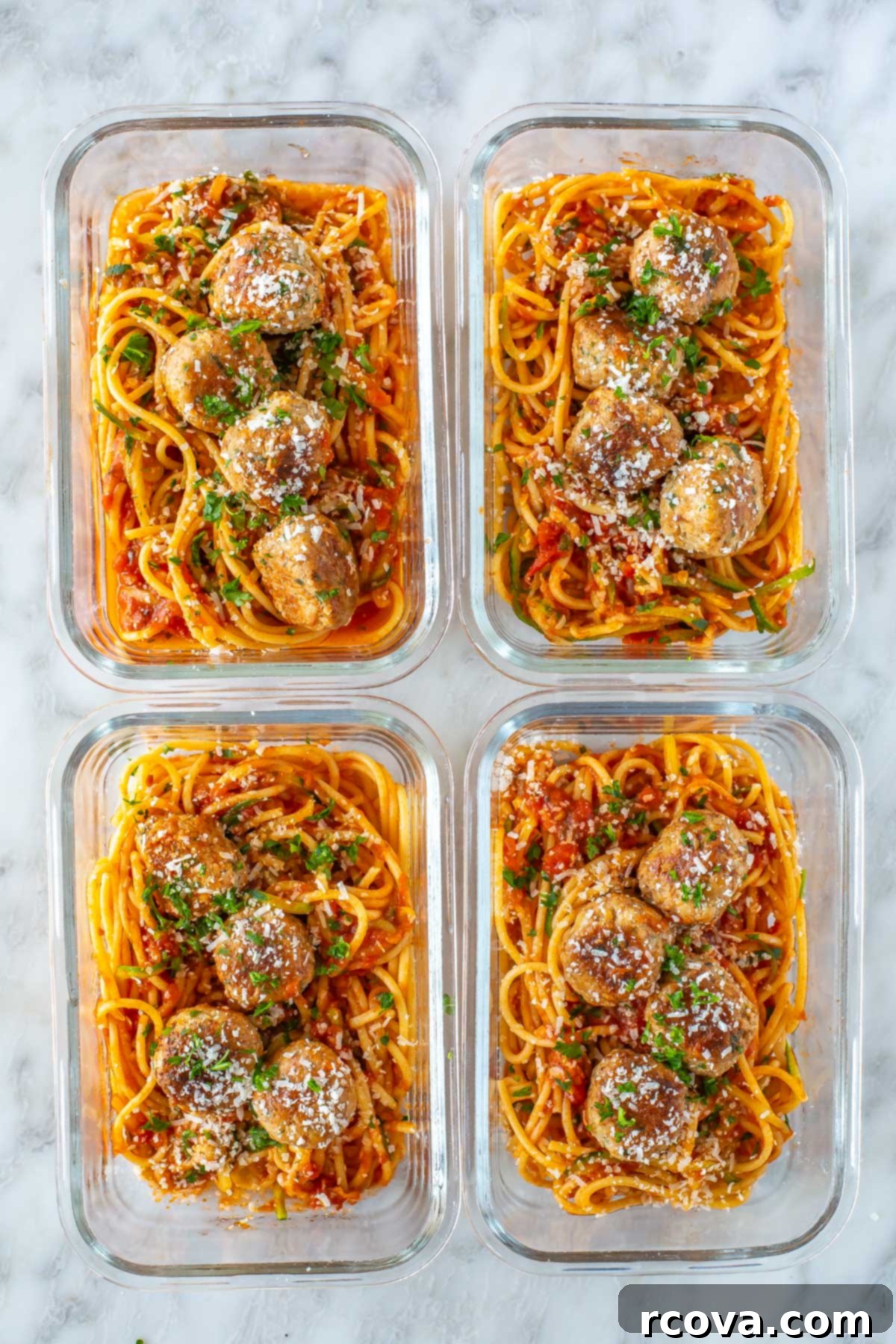 Effortless Oven Baked Turkey Meatballs 8 Four meal prep containers, each with a serving of turkey meatballs with pasta and zucchini noodles.