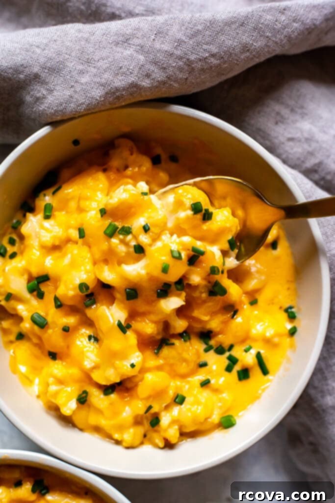 Decadent Low Carb Cauliflower Mac and Cheese 8 Overhead shot of creamy Cauliflower Mac and Cheese in a white bowl, garnished with fresh chives, emphasizing its delicious and healthy nature.
