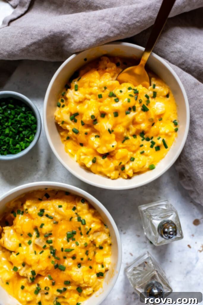 Decadent Low Carb Cauliflower Mac and Cheese 9 A serving of creamy Cauliflower Mac and Cheese in a bowl, with a fork ready to enjoy, highlighting its appeal for meal prep and leftovers.