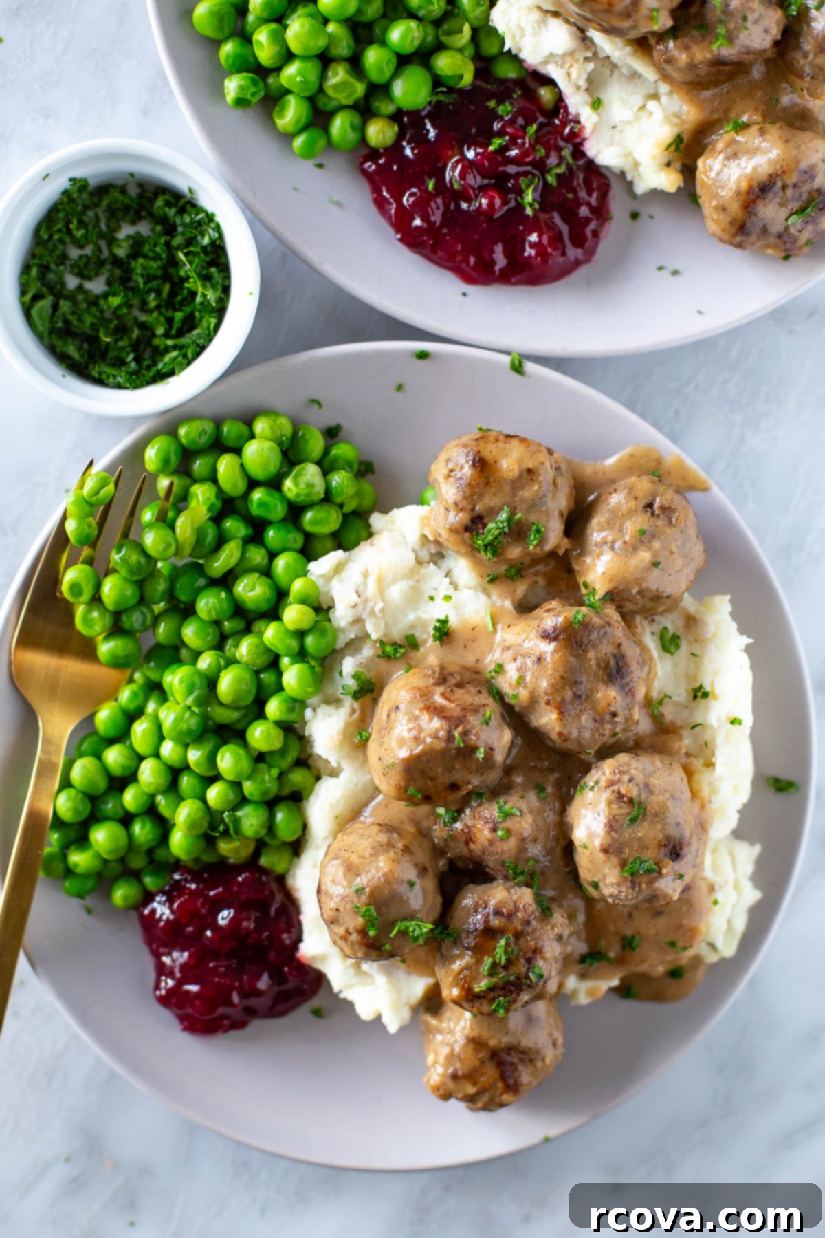 IKEA's Signature Meatballs Slow Cooked 8 Plated Swedish meatballs with mashed potatoes, green peas, and a side of lingonberry jam, ready to be enjoyed.