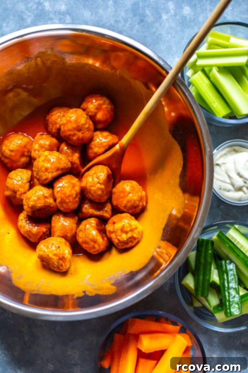Lean Buffalo Chicken Meatballs 5 Meal prep containers with buffalo chicken meatballs, fresh vegetables, and dipping sauce