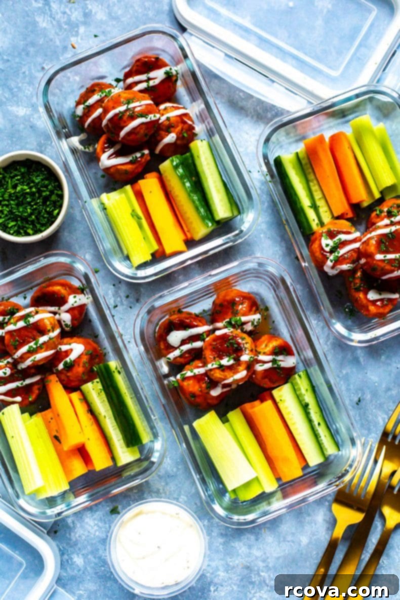 Lean Buffalo Chicken Meatballs 6 A vibrant display of buffalo chicken meatballs served with fresh carrot and celery sticks and a side of creamy dip.