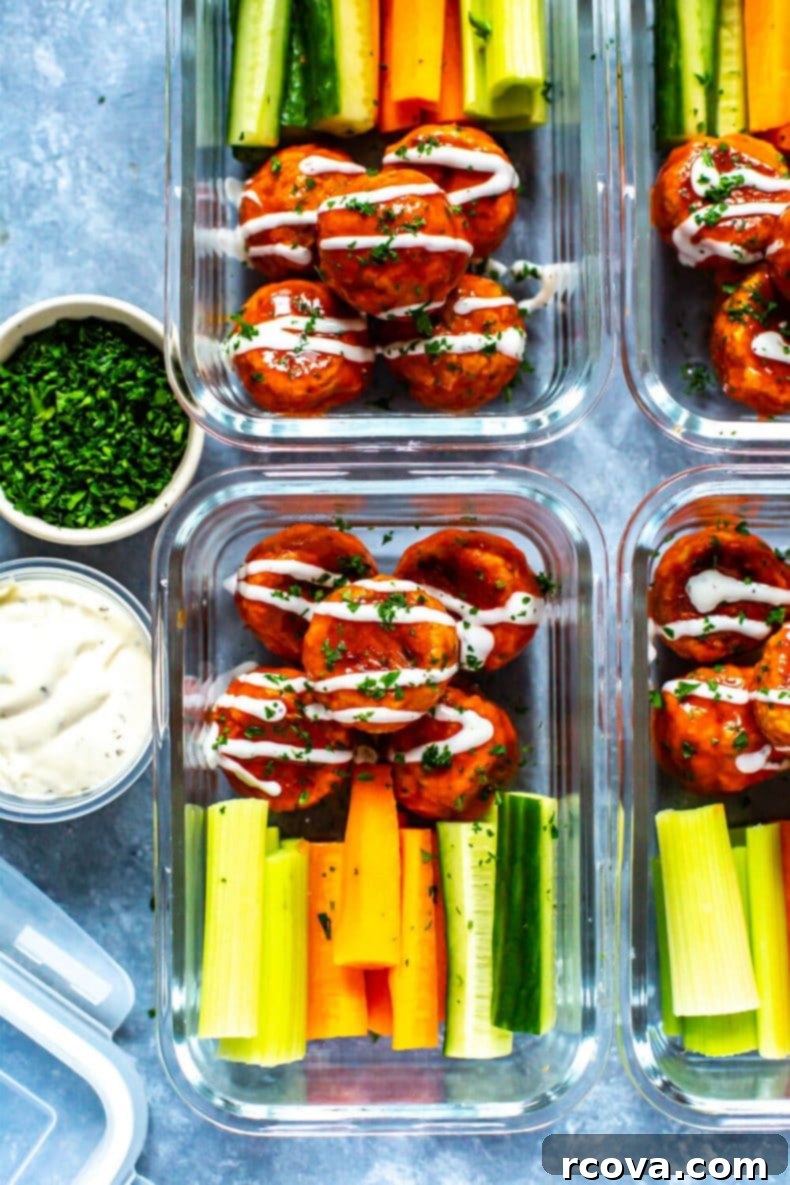 Lean Buffalo Chicken Meatballs 7 Close-up of buffalo chicken meatballs arranged in meal prep containers with fresh vegetables