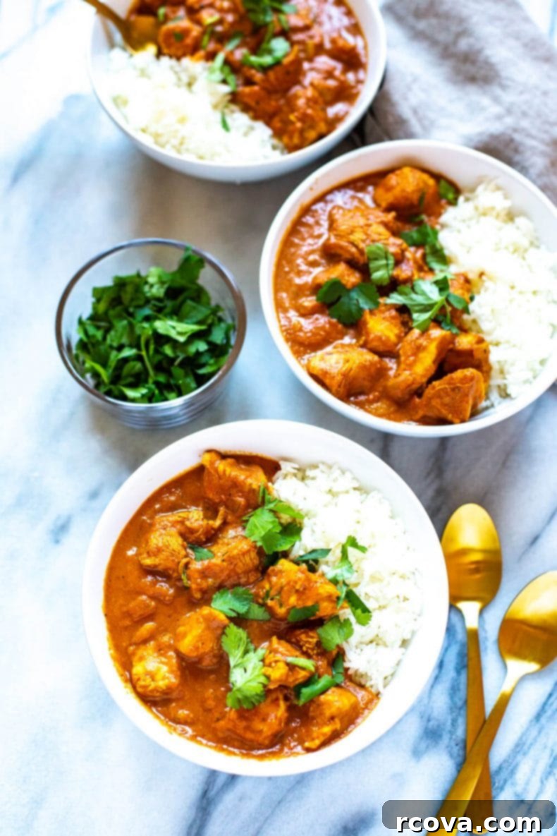 Slow Cooker Chicken Tikka Masala is a delicious, healthy way to enjoy Indian cuisine, and it cooks all day on low so you can enjoy a tasty curry after a long day without all the legwork! #slowcookerrecipes #chickentikkamasala Slow Cooker Chicken Tikka Masala in white bowls, ready to be served