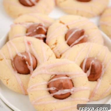Luscious Raspberry Almond Kiss Cookies 6 raspberry almond kiss cookies on a white plate with a pink drizzle