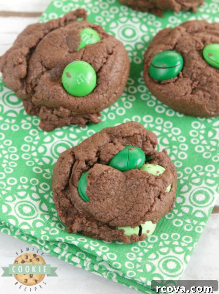 Ultimate Chocolate Mint Cookies 10 Soft and chewy Mint Chocolate Cake Mix cookies, dotted with mint chocolate M&Ms, on a parchment-lined baking sheet.