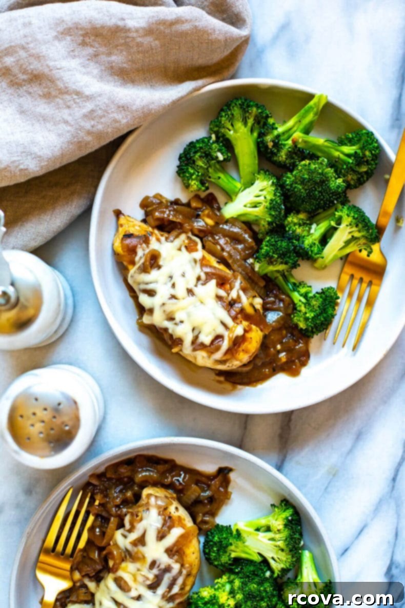 This French Onion Chicken Skillet is a delicious weeknight dinner that is a play on French onion soup and packed with protein, making it a full meal. This will become one of your favorite chicken skillet recipes! Close-up of chicken breast smothered with caramelized onions, gravy, and melted cheese.