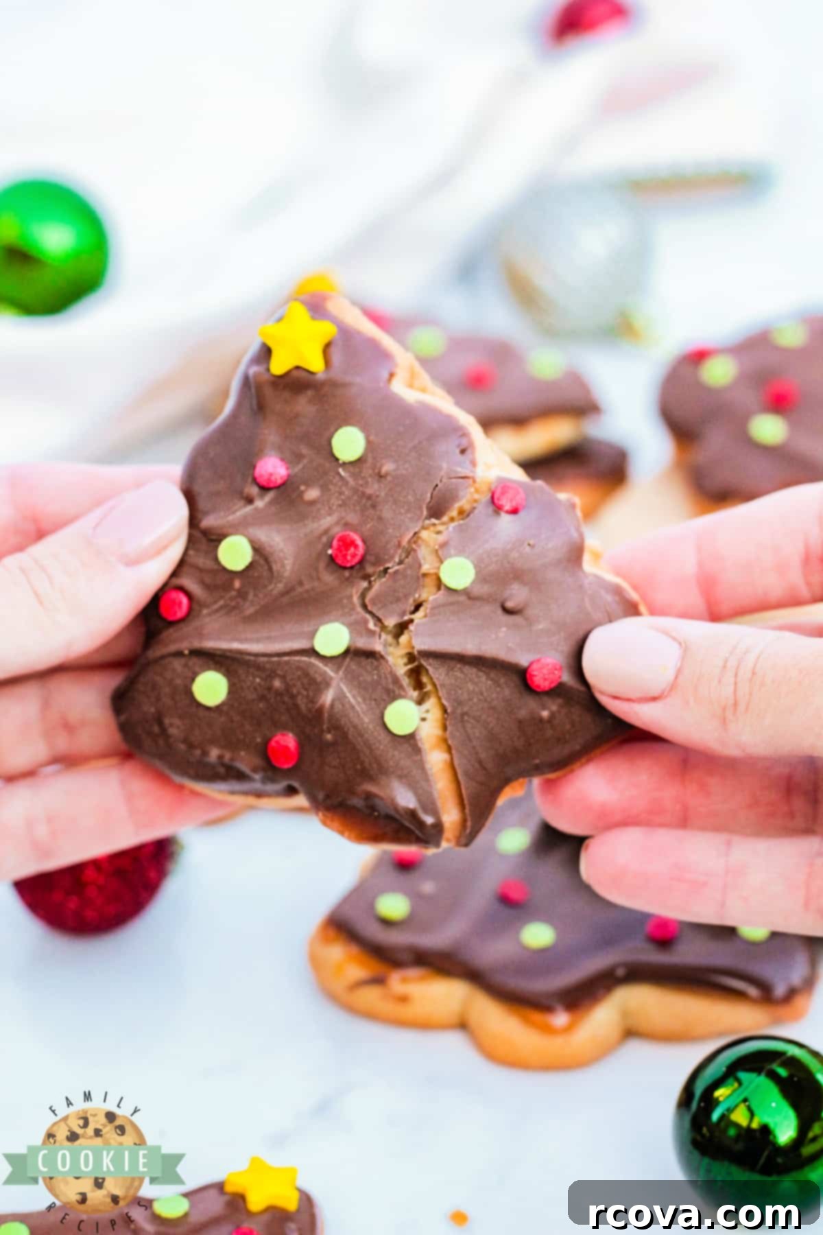 Festive Twix Christmas Tree Cookies 3 Sugar cookies topped with caramel and chocolate.