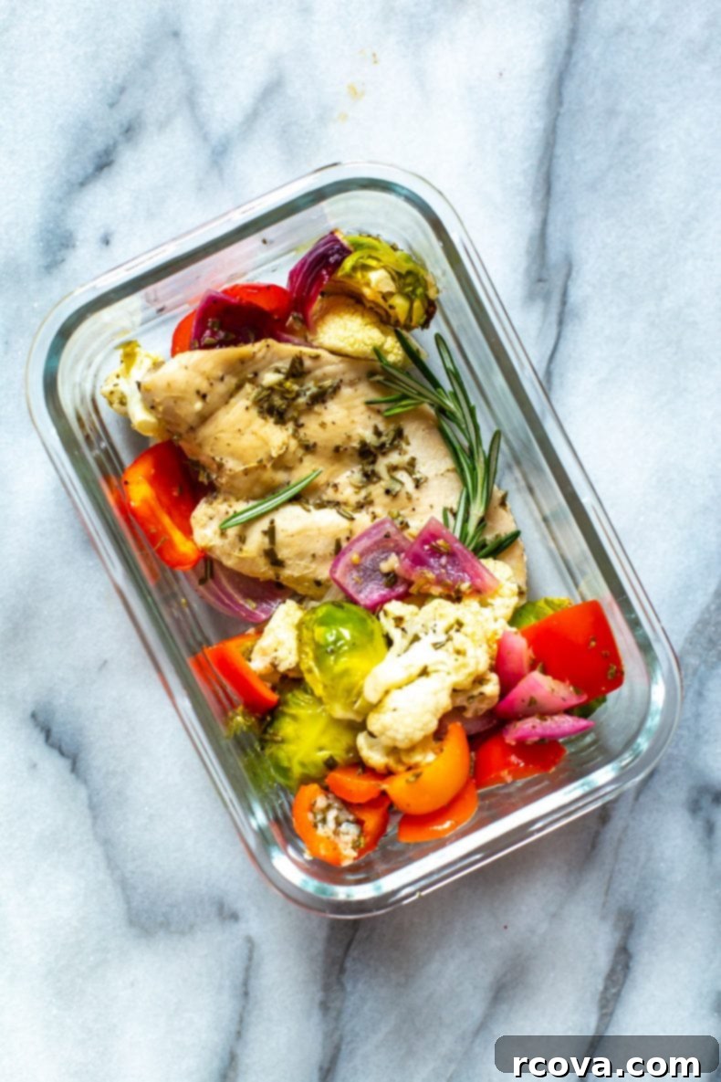 Our Sheet Pan Rosemary Chicken is a healthy, low-carb chicken meal prep recipe. It's perfect as a 30-minute dinner or to pack up as weekly lunch bowls!  Healthy, gluten-free Sheet Pan Rosemary Chicken and roasted vegetables portioned in a glass meal prep container, ready for a nutritious lunch.