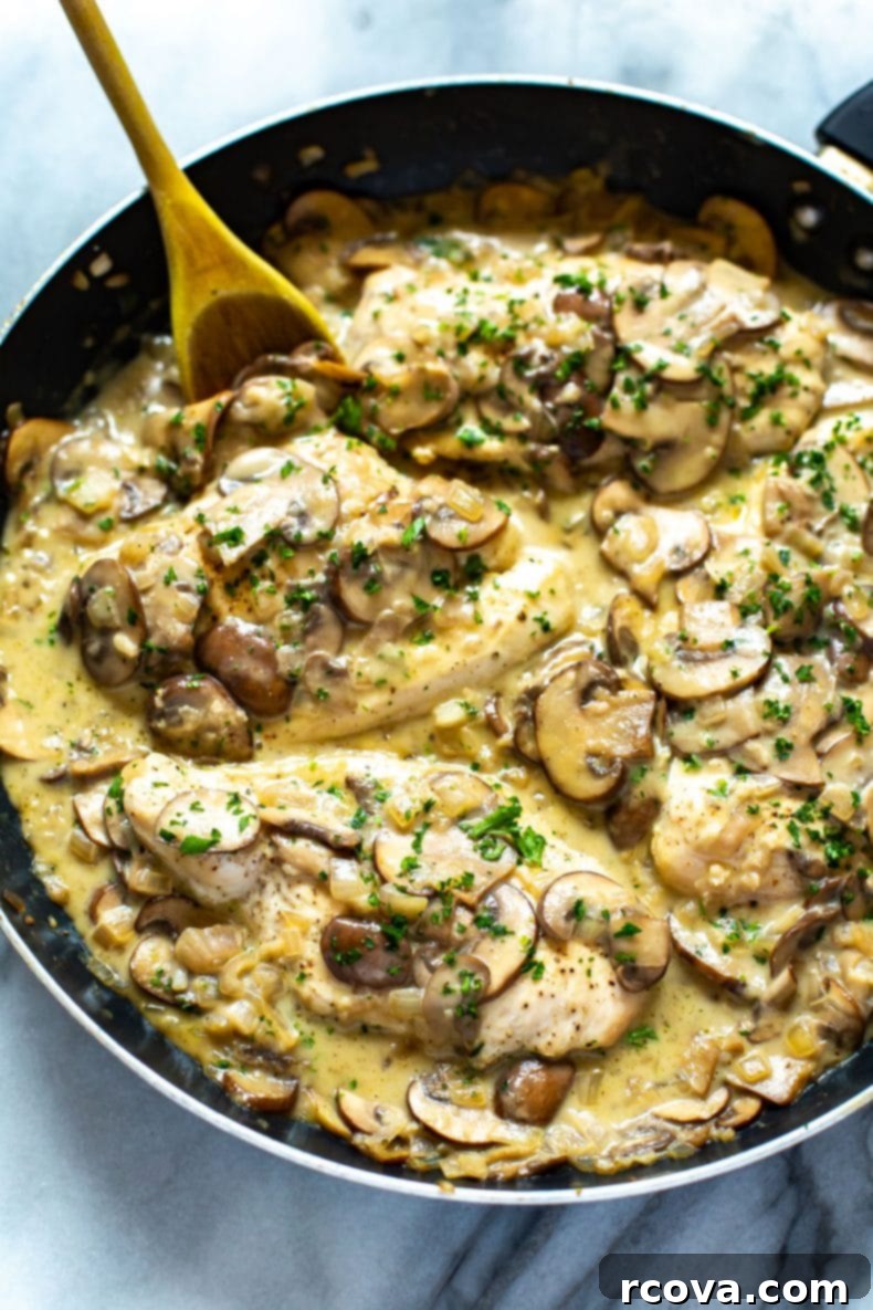This Skinny, Easy Chicken Marsala Skillet is a delicious, creamy mushroom chicken recipe, made healthier with less cream and Marsala wine. It's a one-pan dinner that's freezer-friendly! healthy Chicken Marsala dinner in a large skillet, highlighting a family-style meal