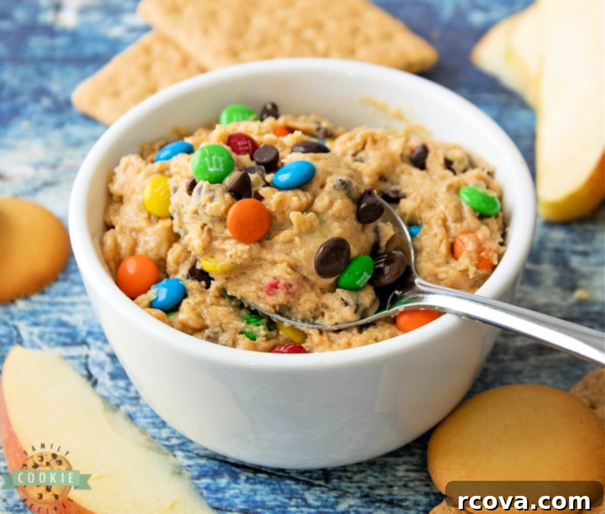 No-Bake Monster Cookie Dough 10 A close-up of edible cookie dough, rich with peanut butter and scattered with mini M&Ms, ready for a taste.