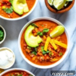 Instant Pot Chili's Copycat Chicken Enchilada Soup 3 Three bowls of Instant Pot chicken enchilada soup with sour cream and cilantro on the side.