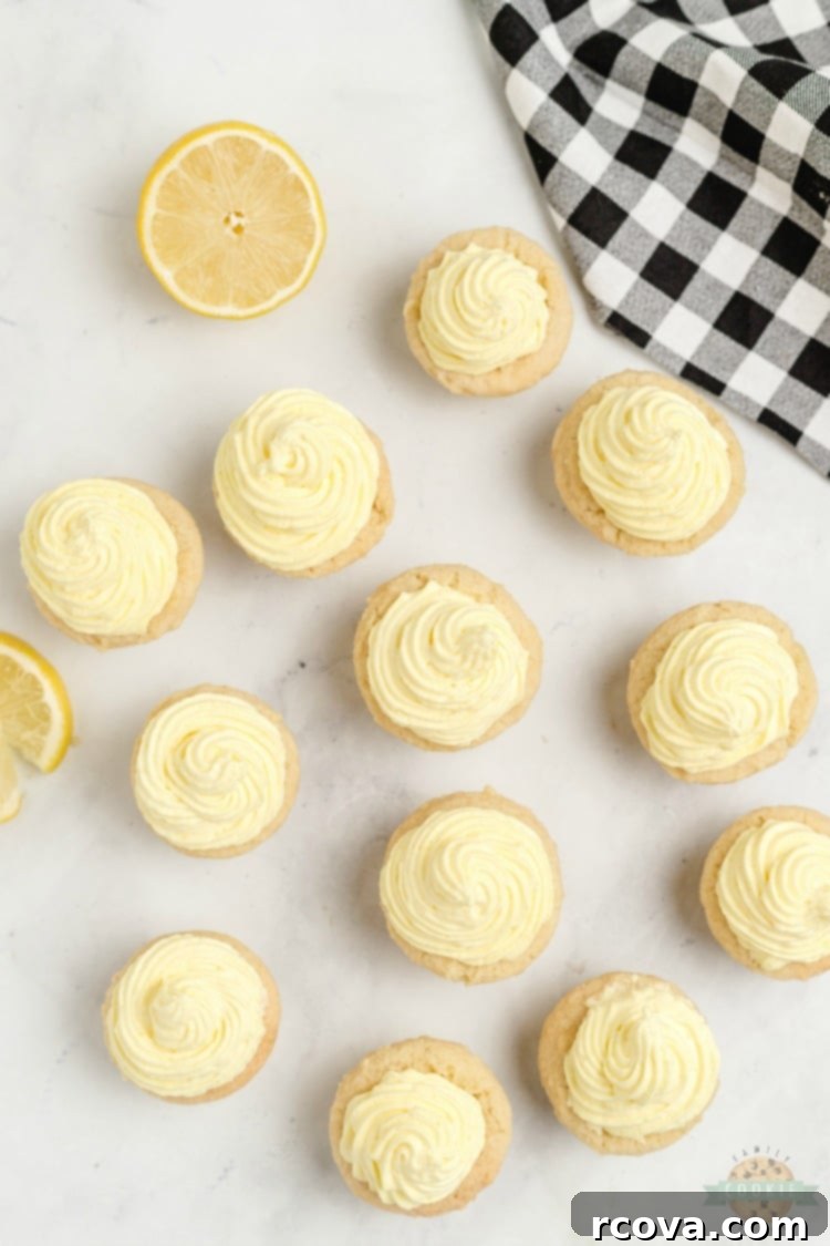 Zesty Lemon Cloud Cookies 11 A beautiful array of Lemon Cream Pie Cookies arranged on a wooden board, with a focus on their bright yellow filling and zest topping.