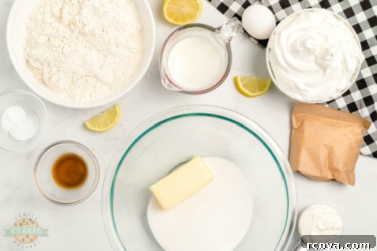 Zesty Lemon Cloud Cookies 5 Various baking ingredients for Lemon Cream Pie Cookies, including flour, sugar, butter, eggs, and a box of lemon pudding mix, artfully arranged on a wooden surface.