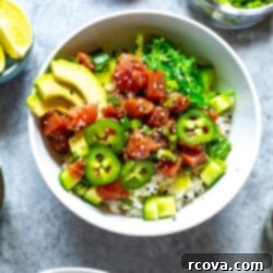 Homemade Ahi Tuna Poke Bowl 6 A close-up of an ahi tuna poke bowl topped with avocado slices, jalapeno slices, and sesame seeds.