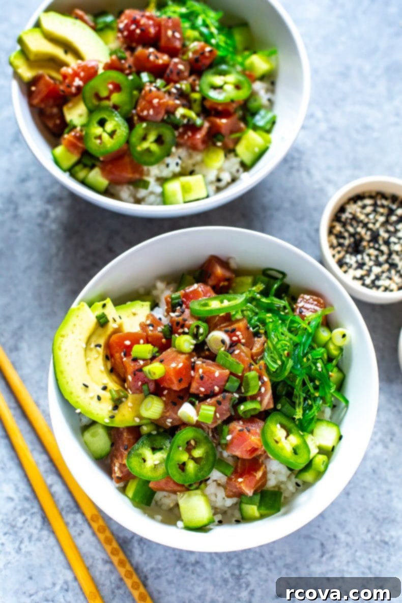 This 30-Minute Ahi Poke Bowl is a quick Hawaiian-inspired recipe with marinated tuna, sushi rice, avocado and seaweed salad - it's just like takeout! Close-up of a homemade Ahi Poke Bowl, richly topped with avocado slices, fresh jalapenos, and crisp cucumber.