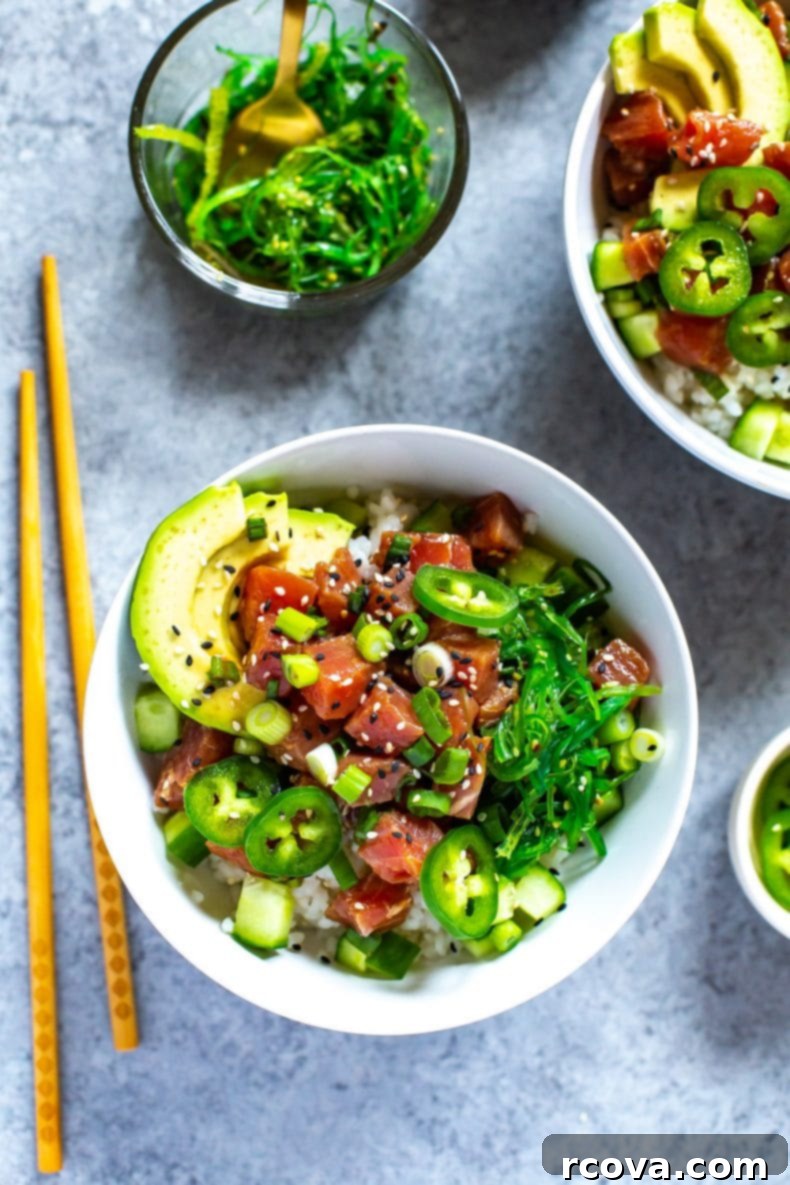 This 30-Minute Ahi Poke Bowl is a quick Hawaiian-inspired recipe with marinated tuna, sushi rice, avocado and seaweed salad - it's just like takeout! A close-up shot of a vibrant Hawaiian raw fish meal, specifically an Ahi Tuna Poke Bowl, ready to be enjoyed.