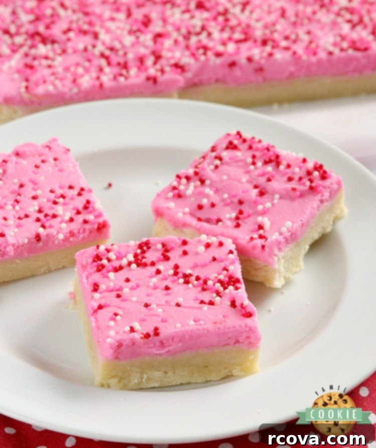 Delicious Sugar Cookie Bars 2 Thick, soft sugar cookie bars with a generous layer of vanilla buttercream frosting, ready to be sliced and served from a baking pan.