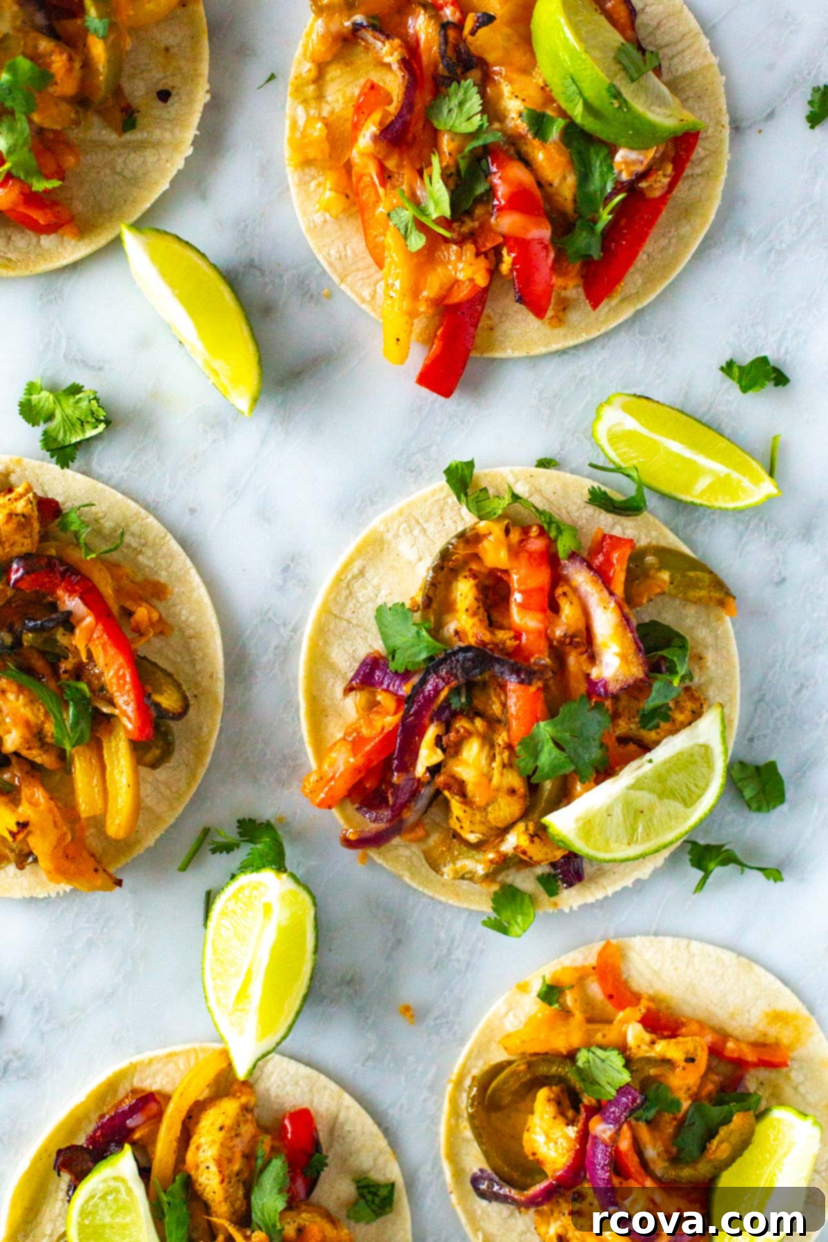 These Sheet Pan Chicken Fajitas are a quick and easy way to enjoy your Tex Mex favorite. This chicken fajita recipe comes together on one pan in 30 minutes! A close-up of sheet pan chicken fajitas, perfectly cooked and served in warm corn tortillas, topped with fresh cilantro and lime.