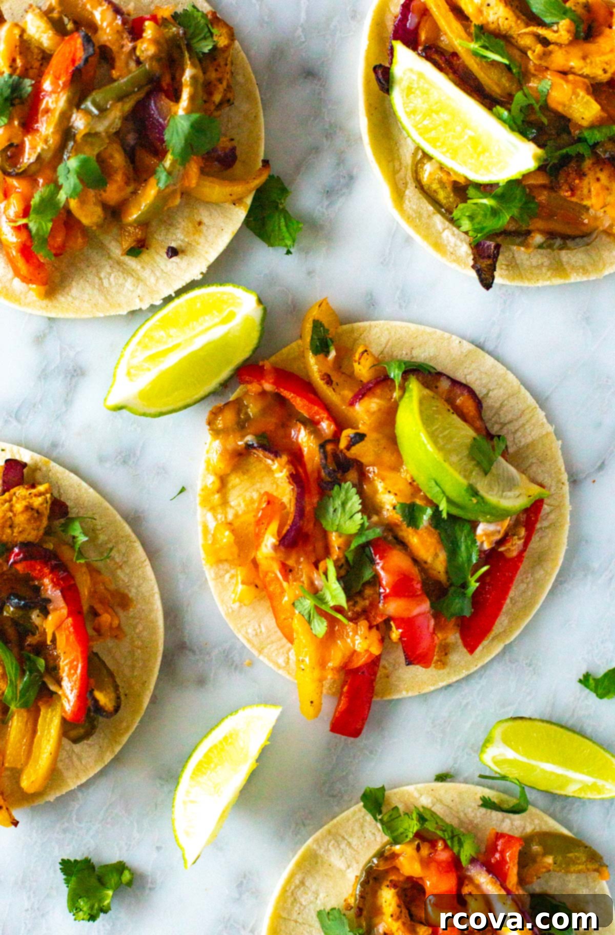These Sheet Pan Chicken Fajitas are a quick and easy way to enjoy your Tex Mex favorite. This chicken fajita recipe comes together on one pan in 30 minutes! A vibrant platter of sheet pan chicken fajitas, showcasing perfectly cooked chicken and colorful bell peppers, ready to be wrapped in tortillas.