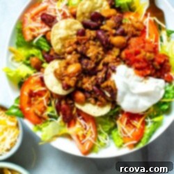 Recreate The Famous Wendys Taco Salad 3 A close-up of a bowl of Copycat Wendy's Taco Salad with a fork in it.