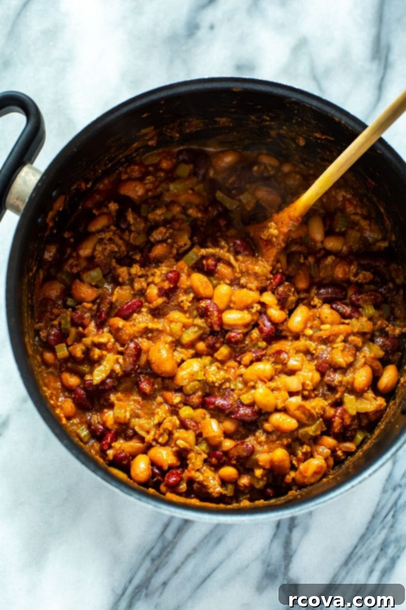 A close-up of Wendy's chili cooking, a core component of the copycat taco salad recipe. Making homemade version of Wendy's chili in a large pot, showing the rich texture.