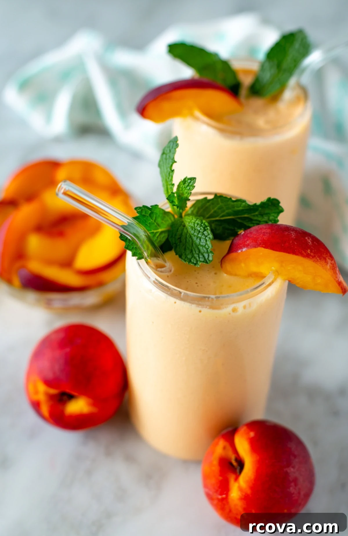 Power-Packed Protein Blends for Wellness 10 Side shot of two peach smoothies garnished with peach slices and mint leaves, a refreshing and high-protein drink.