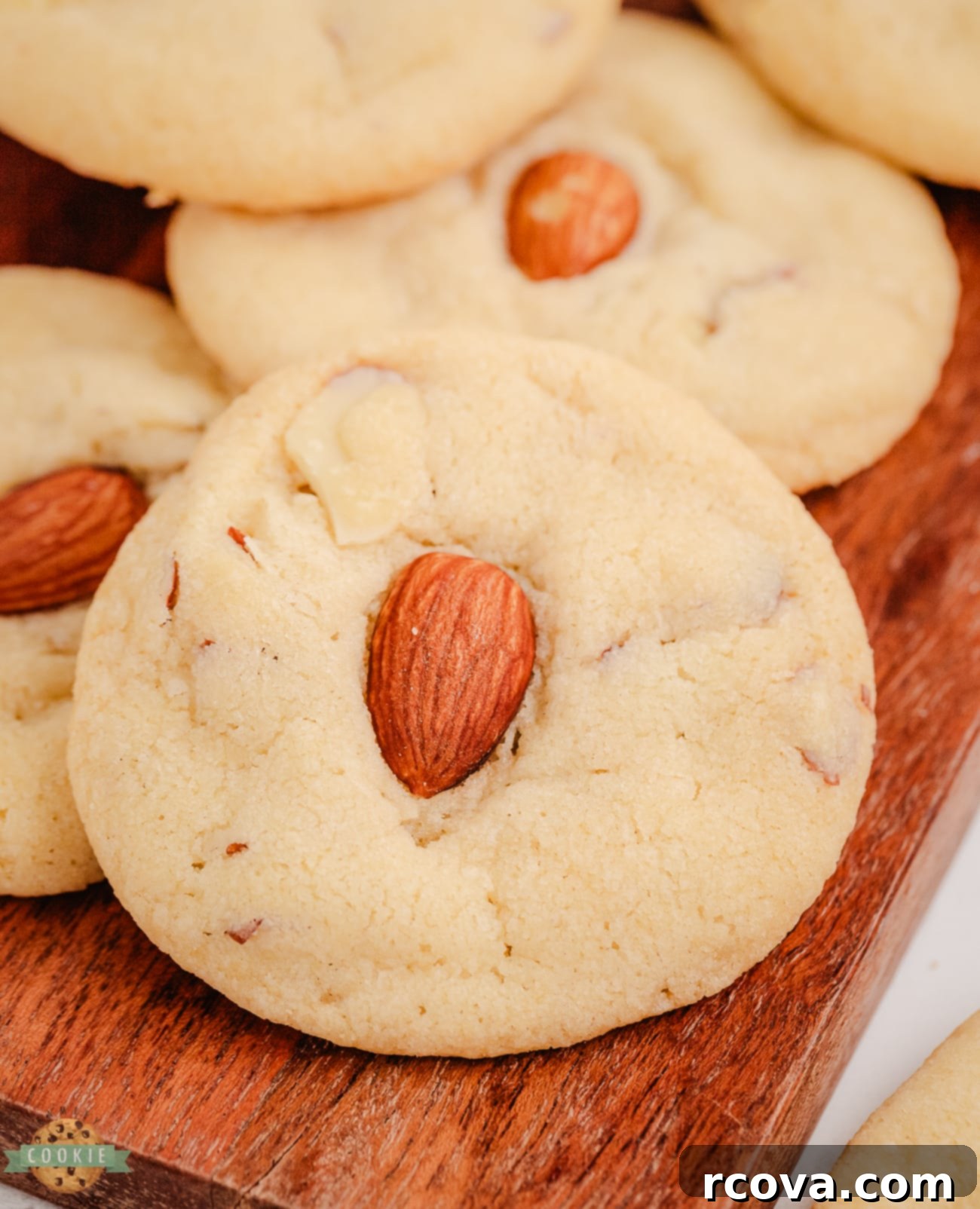 Golden Almond Delights 5 beautifully baked buttery drop cookies, each adorned with a whole almond, arranged on a baking sheet, ready to be enjoyed