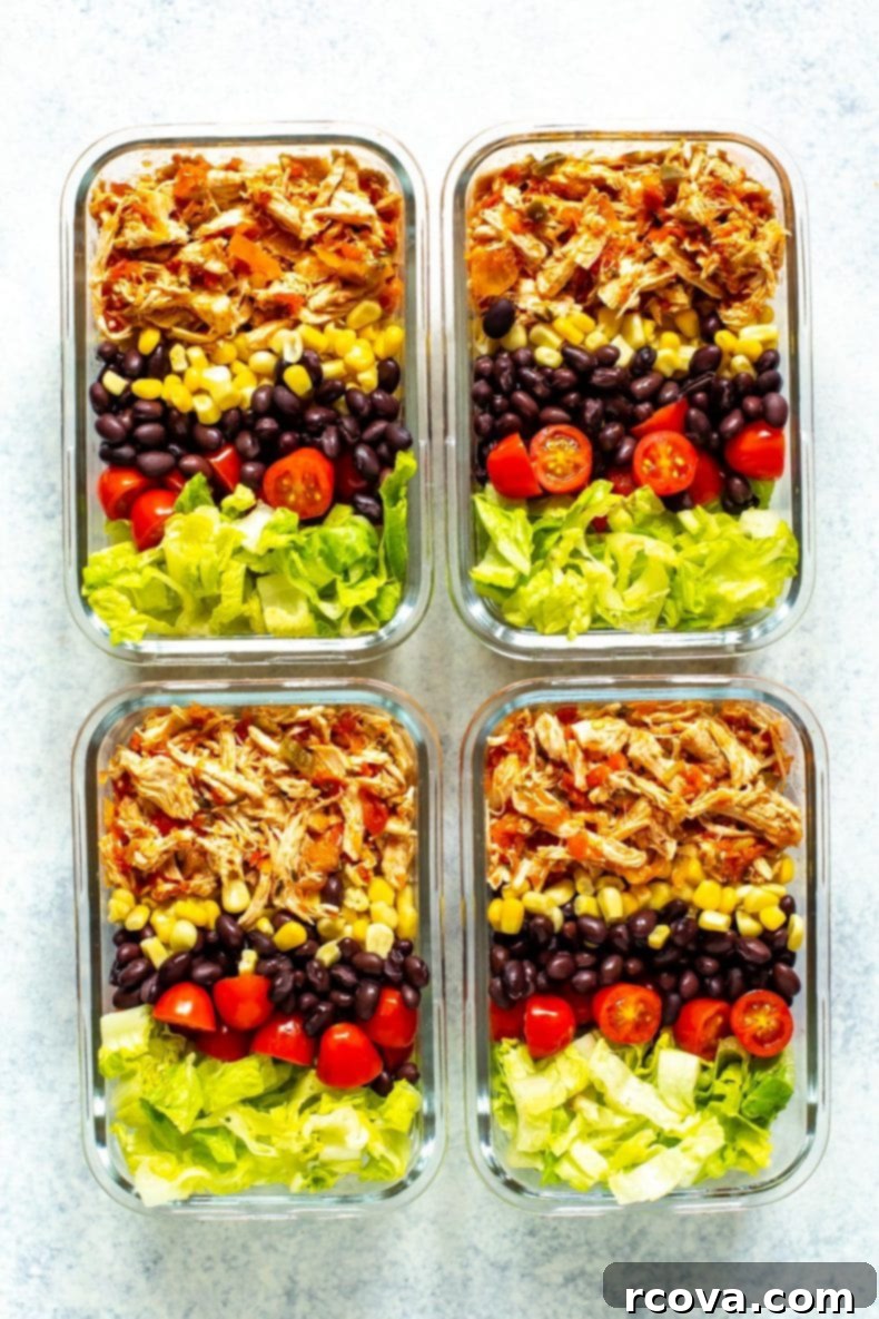 Effortless Two Ingredient Salsa Chicken 7 Four meal prep containers, each containing crockpot salsa chicken, corn, black beans, cherry tomatoes and lettuce, neatly packed.