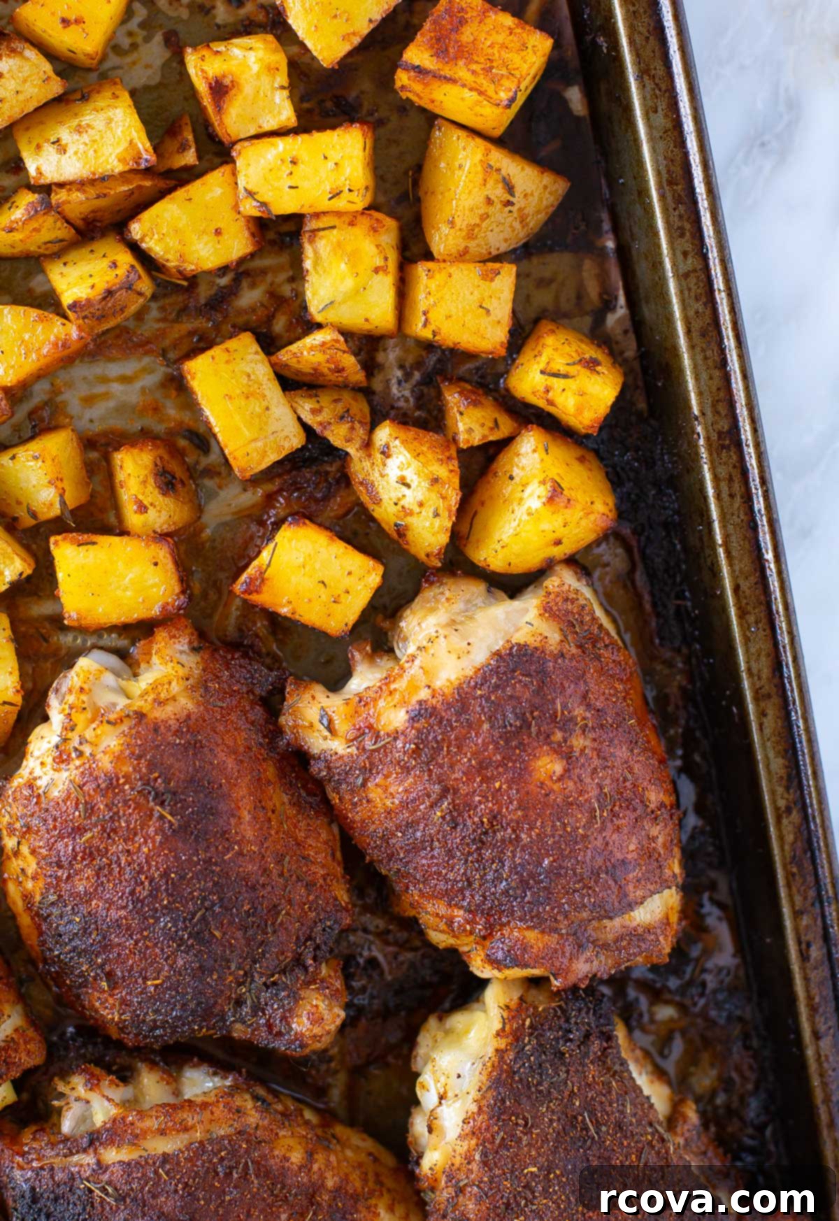 Succulent Baked Chicken Thighs with Crispy Skin 8 Baked chicken thighs cooking on a sheet pan in the oven, looking golden and delicious.