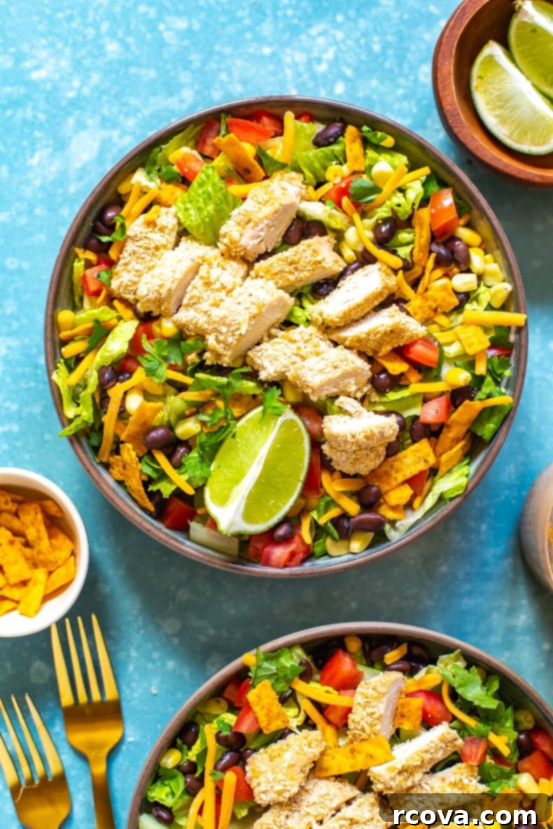 Homemade McDonald's Southwest Salad Recipe 8 A bowl of Copycat McDonald's Southwest Salad pictured with forks, tortilla strips, limes and another bowl of salad.