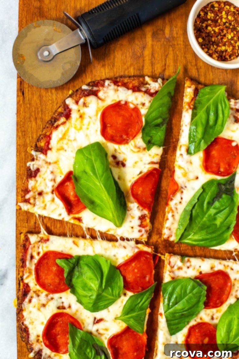 Ultimate 3-Ingredient Cauliflower Pizza Crust 9 A stunning shot of a finished Cauliflower Crust Pizza, sliced and ready to eat, with its healthy and delicious toppings.