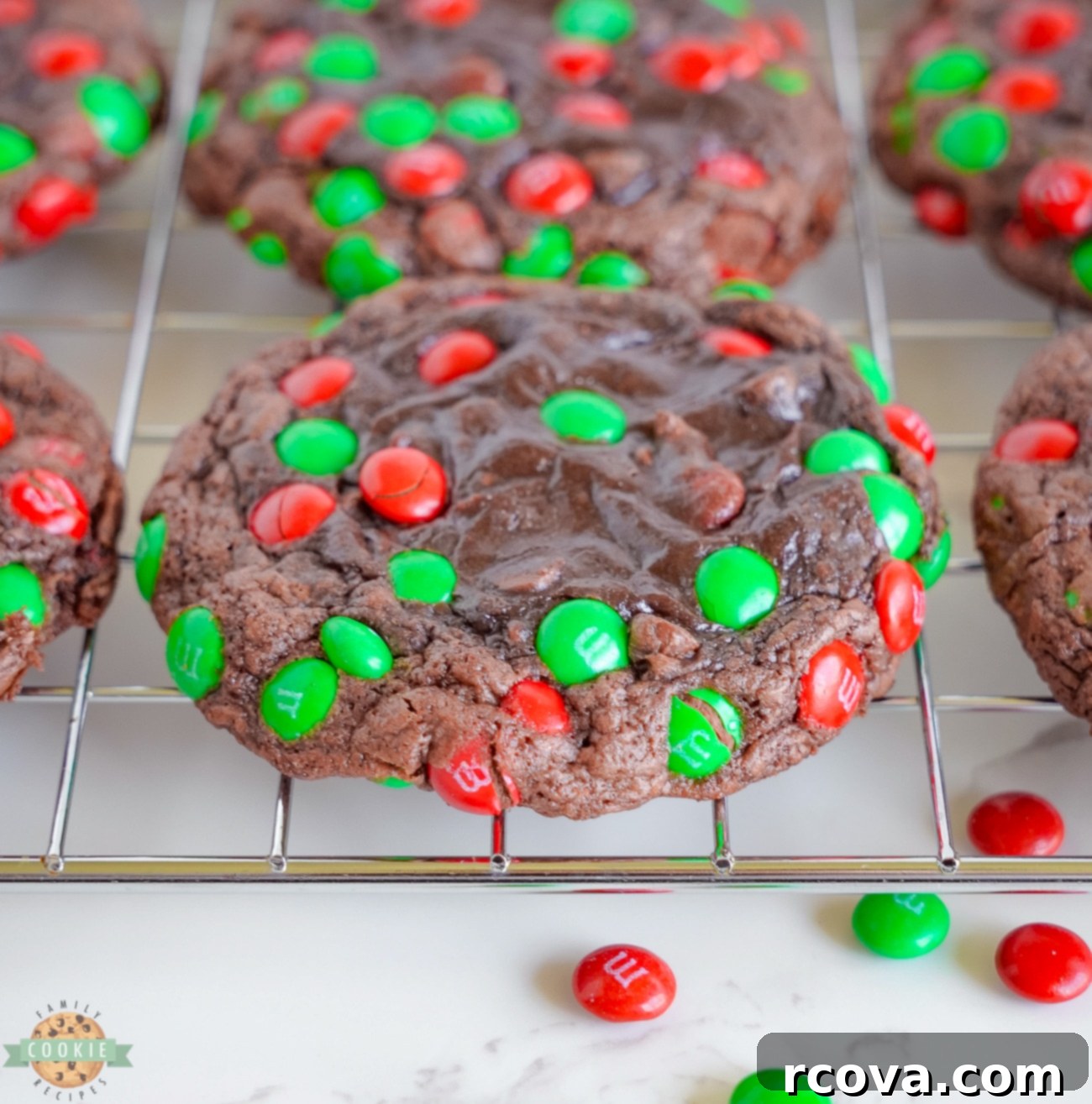 Christmas M&M Brownie Cookies 2 brownie cookies topped with Christmas M&M's on a cooling rack
