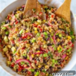 Speedy & Satisfying Quinoa Salad 9 Overhead shot of quinoa salad with two wooden spoons tossing the salad