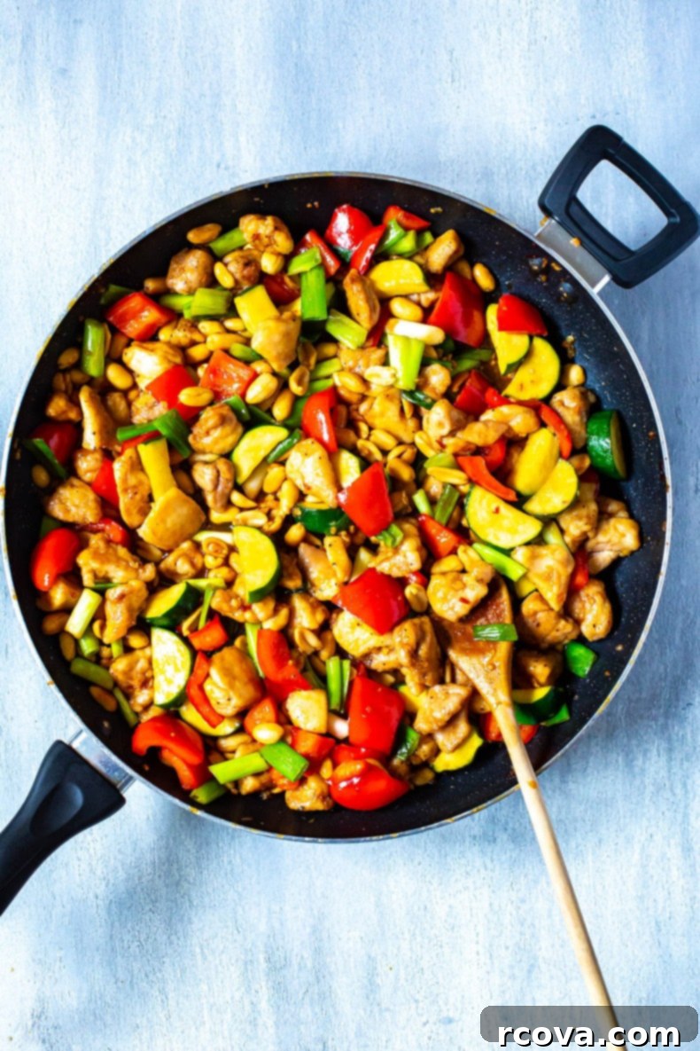 The Best Homemade Panda Express Kung Pao Chicken 2 A vibrant plate of homemade Panda Express Kung Pao Chicken served with jasmine rice, garnished with green onions and peanuts.