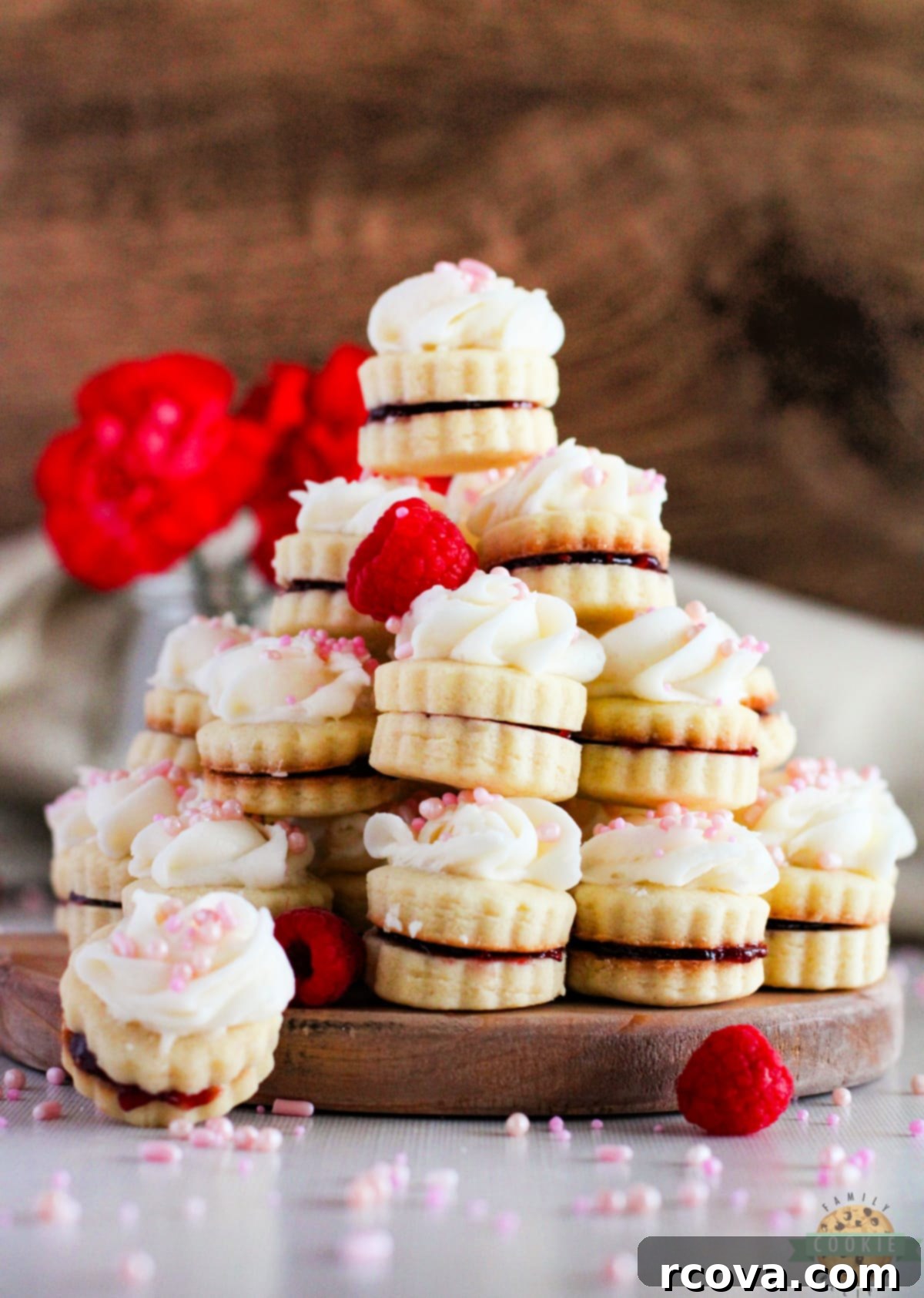 Imperial Delights 2 Empire Cookies are buttery shortbread cookie sandwiches filled with raspberry jam and topped with a simple buttercream frosting. Delicious cookies that are both pretty and delicious!