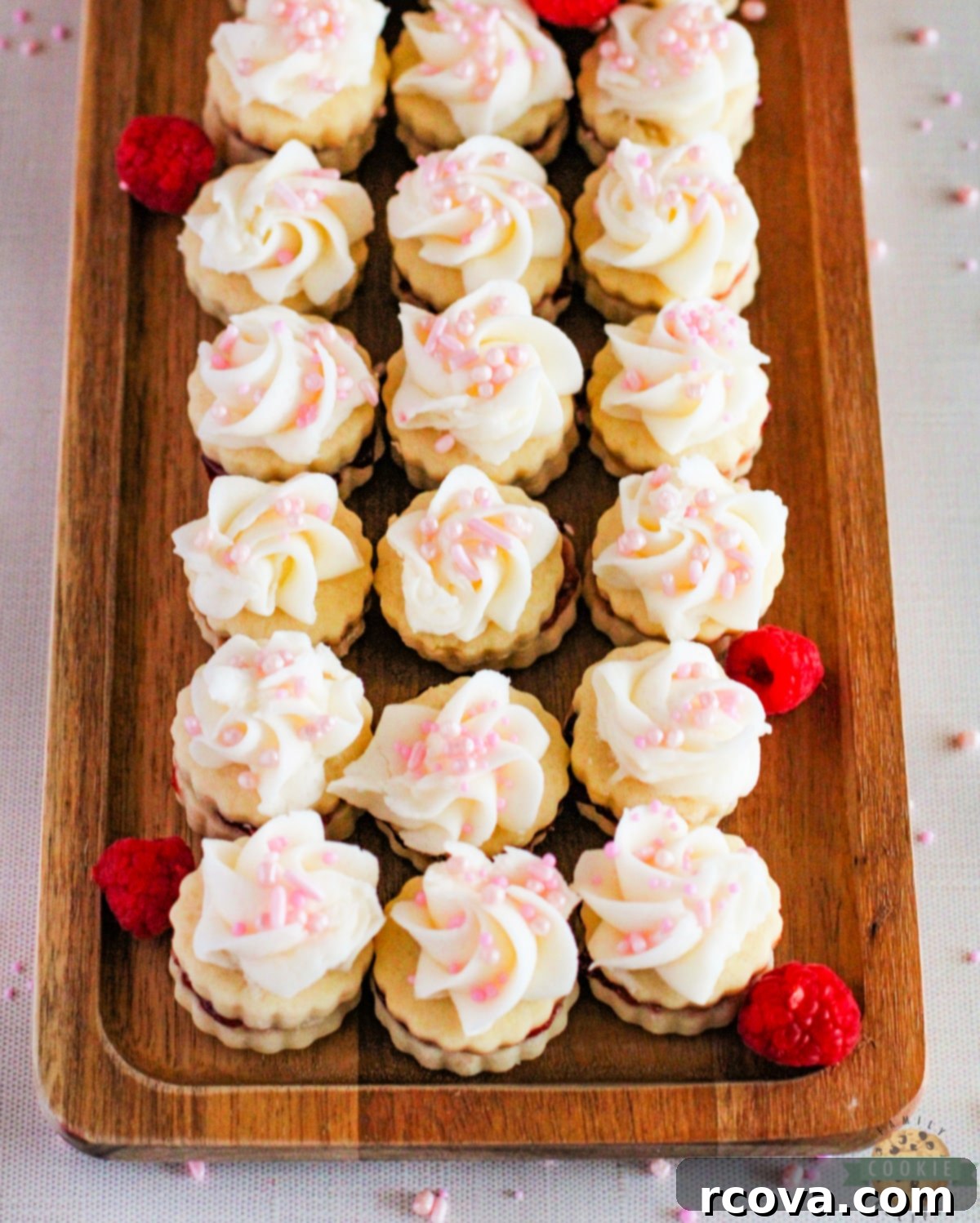 Imperial Delights 15 Empire Cookies are buttery shortbread cookie sandwiches filled with raspberry jam and topped with a simple buttercream frosting. Delicious cookies that are both pretty and delicious!