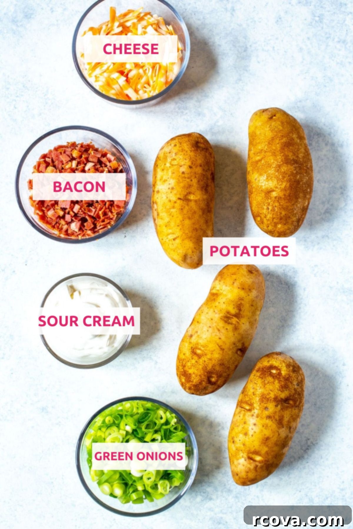 Set and Forget Crockpot Potatoes 4 Fresh ingredients for crockpot baked potatoes arranged on a wooden board: russet potatoes, shredded cheddar cheese, crispy bacon, sour cream, and chopped green onions.