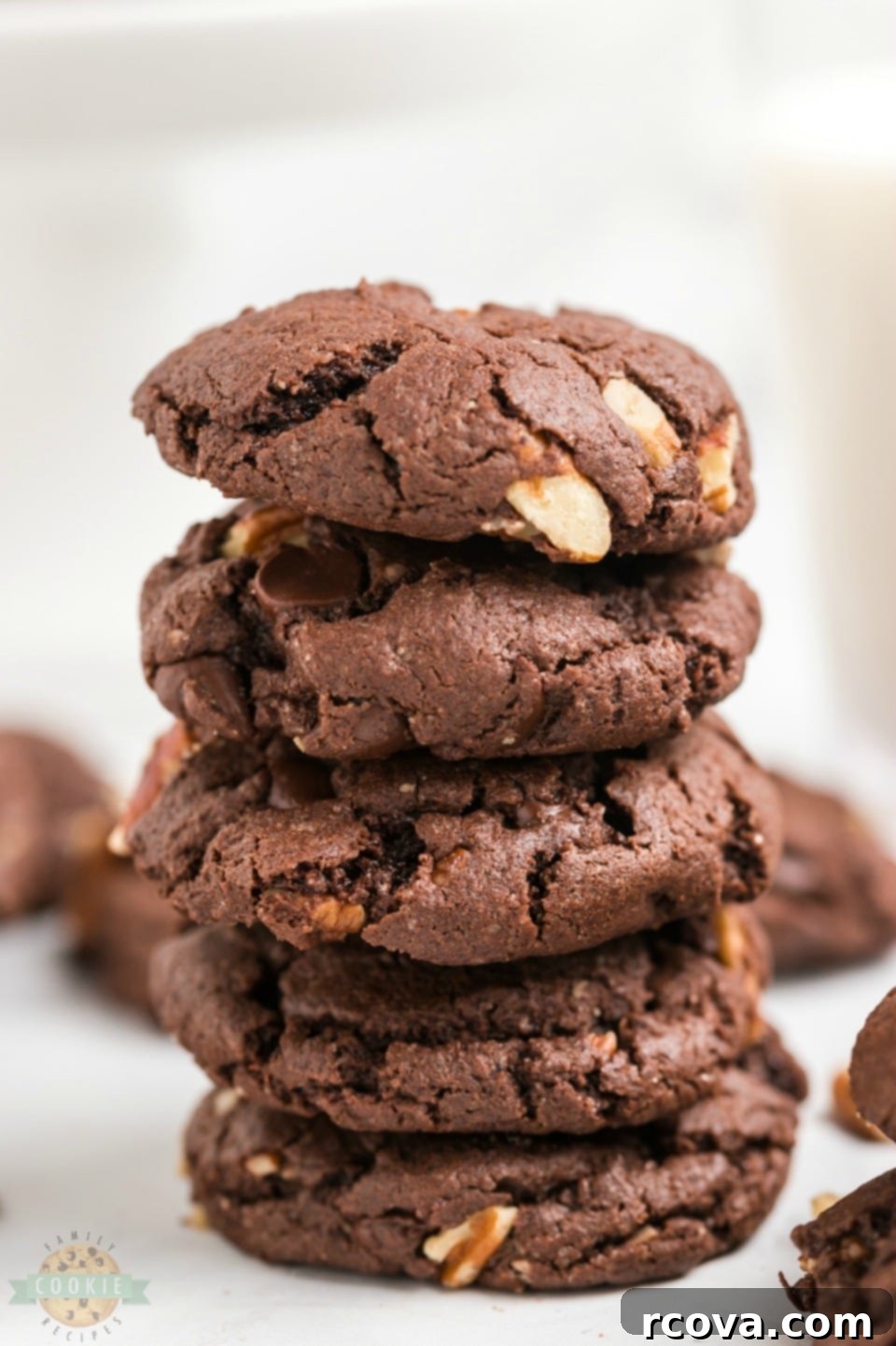 Cake Mix Magic Chocolate Cookies 8 A pile of perfectly baked chocolate cake mix cookies with visible chocolate chips and pecans, ready to be enjoyed.