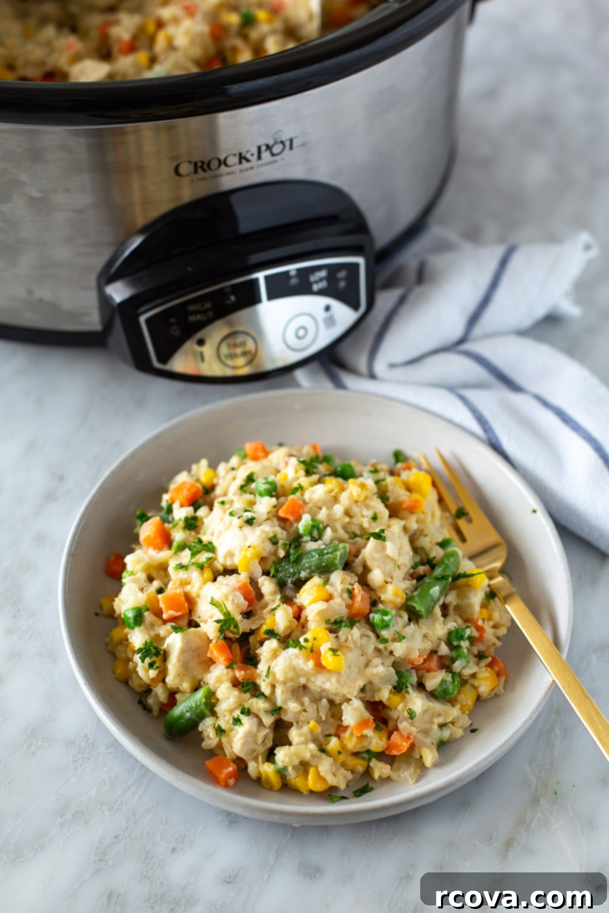 Effortless Slow Cooker Chicken and Rice 8 A serving bowl of creamy chicken and rice next to a slow cooker, ready to be enjoyed.